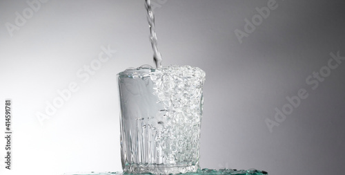 Pour water into the glass separating the white and dark background.