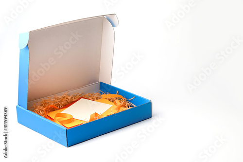 Gift box with blank paper card. Concept of gift card surprise and festive greetings.