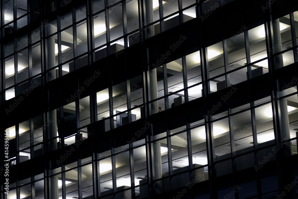 Fully lit office building at night with cubicles visible through windows  Stock Photo | Adobe Stock