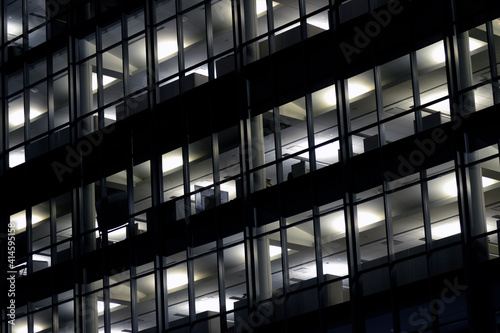Fully lit office building at night with cubicles visible through windows