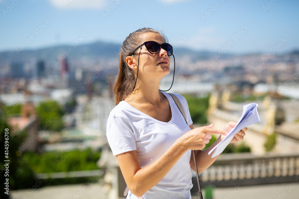 Portrait of young adult woman exploring outdoors exposition using paper guide