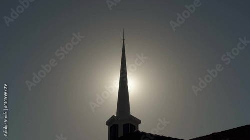 Sun Rays Peek through Silhouetted Mormon Church Spire with Slow Zoom In (Wide Angle Exterior 4K) photo