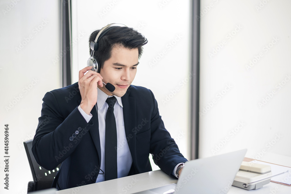 Asian business man wearing a headset is ready to serve customers at the office. Asian business man wearing a headset is ready to serve customers at the office.