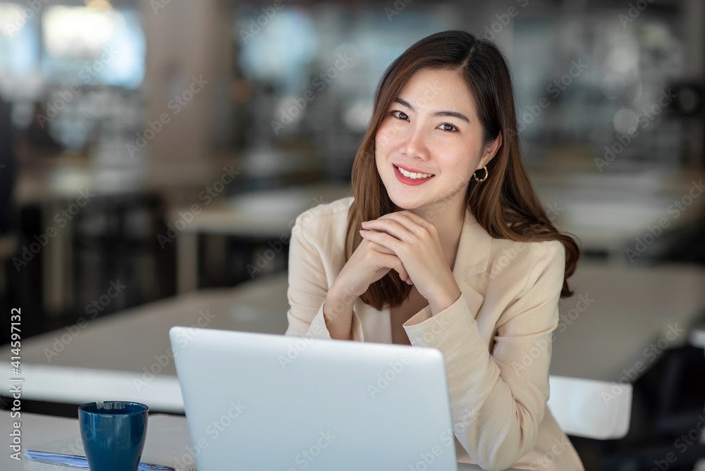 Asian businesswomn sitting working at the office. Looking at camera. Asian businesswomn sitting working at the office. Looking at camera.