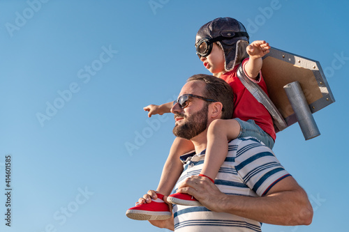 Fototapeta Naklejka Na Ścianę i Meble -  Father and son playing against blue summer sky background