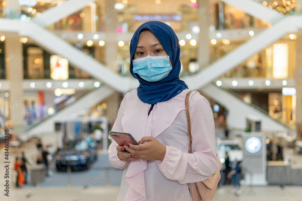 Cute Malay Girl at the mall going shopping wearing face mask Cute Malay Girl at the mall going shopping wearing face mask