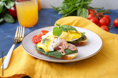 Tasty sandwiches with florentine eggs and bacon on color background
