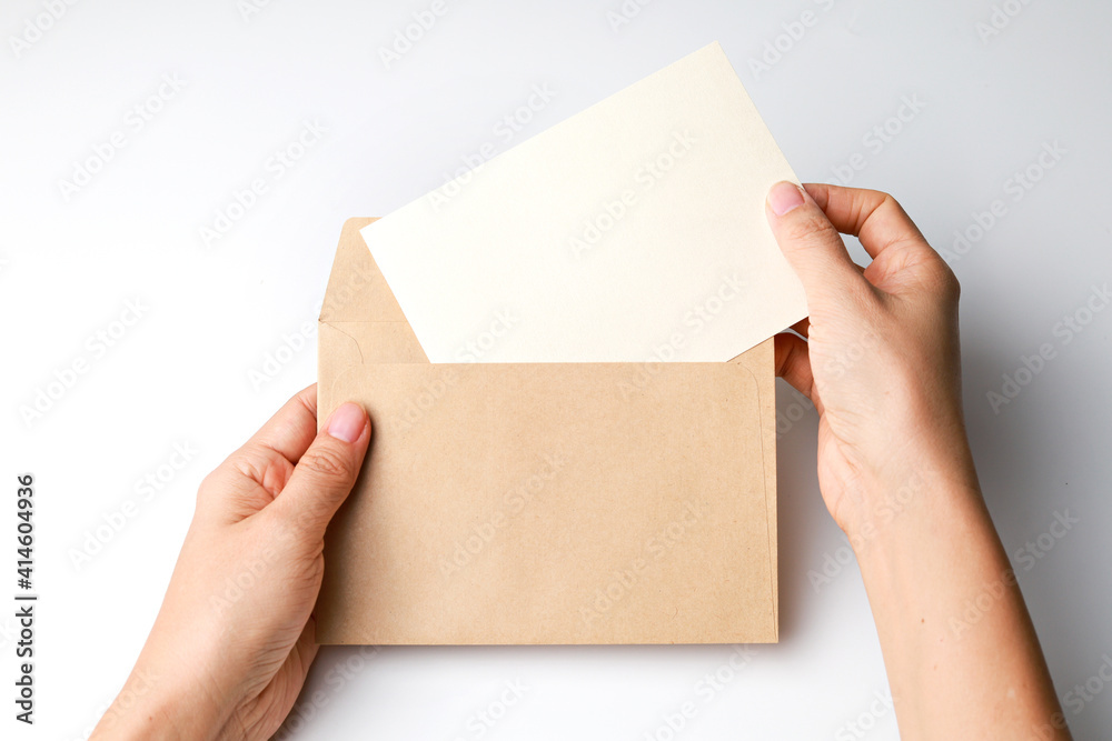 Hand holding envelope and blank card isolated on white background.
