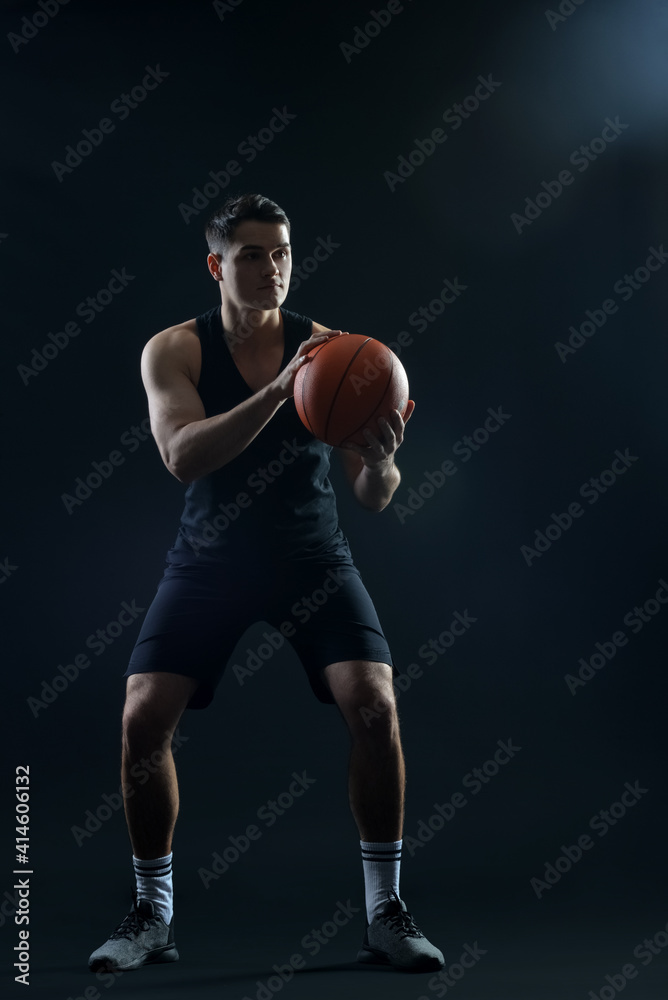 Male basketball player on dark background