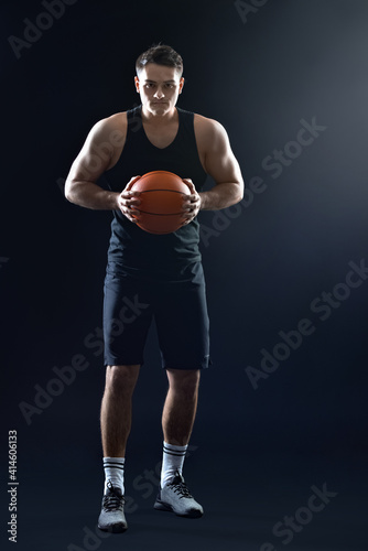 Male basketball player on dark background