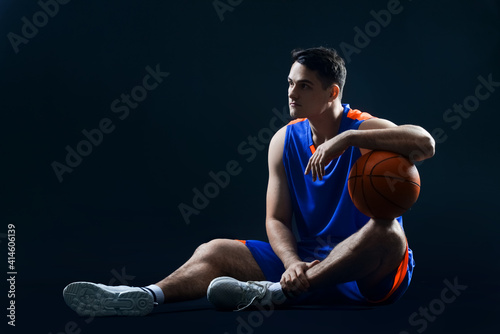 Male basketball player on dark background