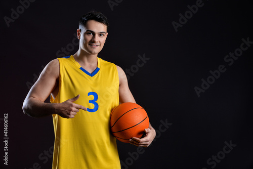 Male basketball player on dark background