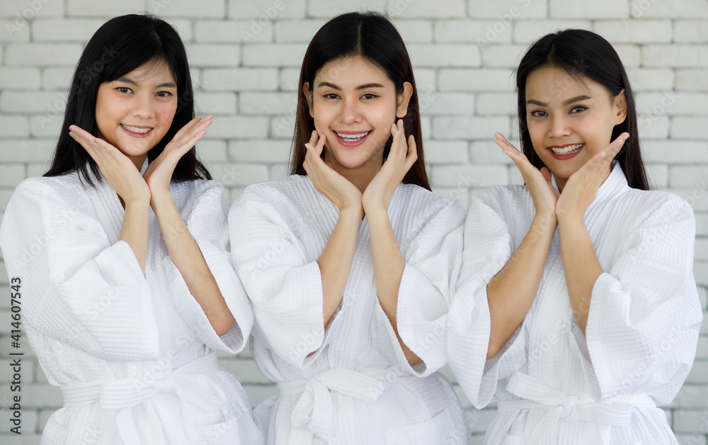 Portrait 3 asian adults women with long black hair wearing apa style white robes Smiling and looking at the camera her hands touched on her face looked happy with her skin face. Shoot in a studio room - obrazy, fototapety, plakaty 