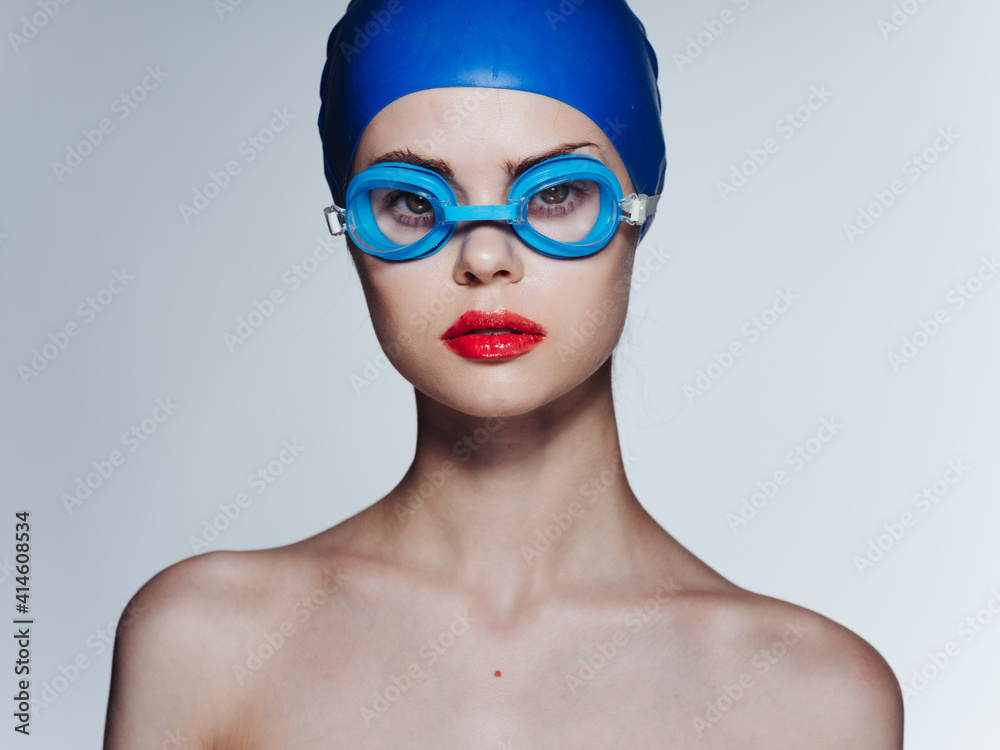 Woman with swimming goggles and blue cap cropped view