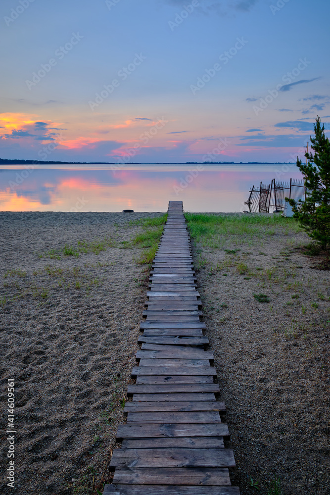 Fototapeta premium wooden path to the lake at sunset