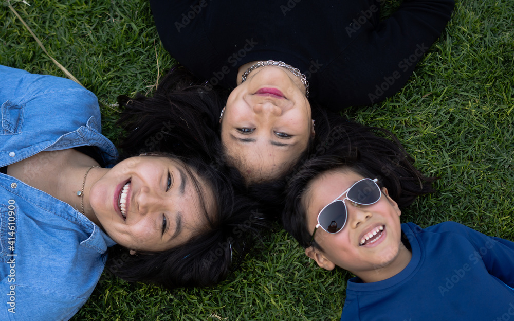 Brothers looking at the sky lying on the grass in a park Brothers looking at the sky lying on the grass in a park
