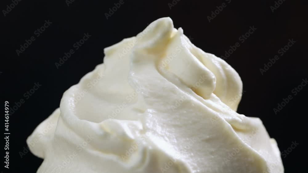 close up of rotating whipped cream on black background close up of rotating whipped cream on black background