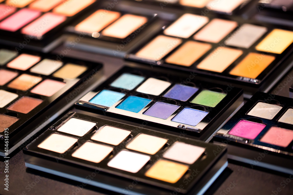 Eyeshadows, powder, makeup base and correctors for the skin in sets lie on the shelves in a store or beauty salon. Probes of different cosmetics from a professional makeup artist. Eyeshadows, powder, makeup base and correctors for the skin in sets lie on the shelves in a store or beauty salon. Probes of different cosmetics from a professional makeup artist.