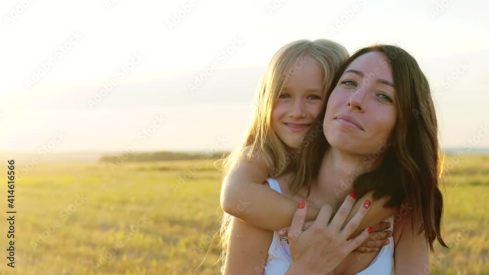Happy mother and little daughter at sunset. Silhouettes of mother and little daughter walking at sunset. mother with child enjoying together in sunny nature. Happy mother and little daughter at sunset. Silhouettes of mother and little daughter walking at sunset. mother with child enjoying together in sunny nature.