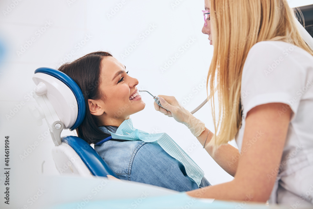 Positive delighted female person visiting her dentist Positive delighted female person visiting her dentist