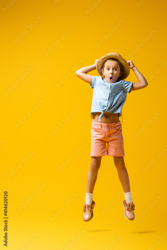 full length of shocked kid in straw hat levitating on yellow full length of shocked kid in straw hat levitating on yellow