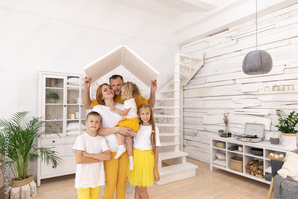 Happy young family under a safe roof, concept. a friendly family moves to their apartment. Copy space.