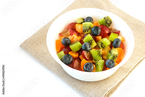 Fresh fruit salad for breakfast in a white bowl on an isolated white background.