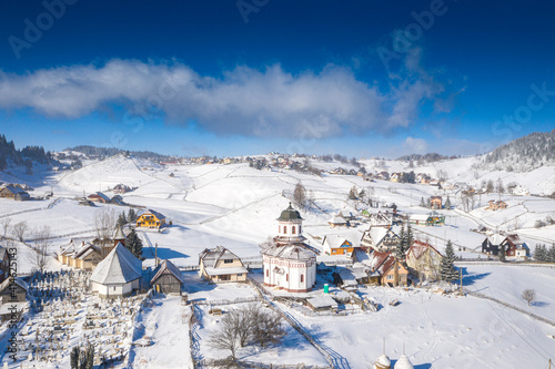 Aerial scenic rural view of the winter landscape from Fundata village in Romania at the bottom of Bucegi Mountains  photo