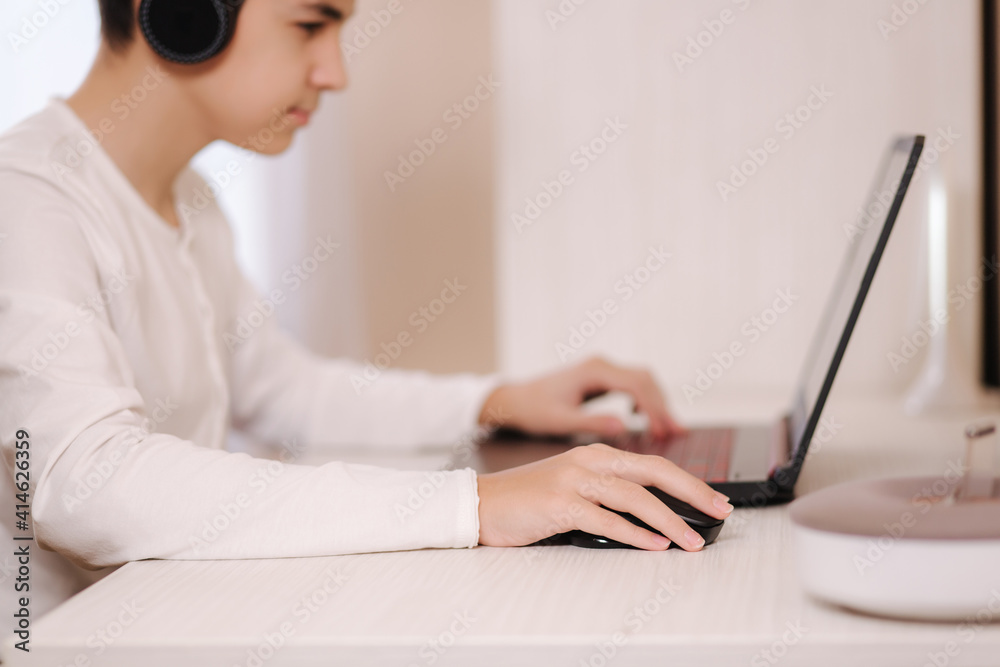 Teenage boy playing game on his pc computer in white room. Gamer capture video on web camera on laptop. Focus on hand Teenage boy playing game on his pc computer in white room. Gamer capture video on web camera on laptop. Focus on hand