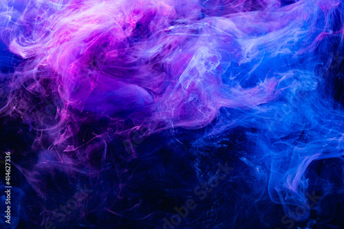 Paint in water. Colorful art background. Fluorescent smoke texture. Universe energy. Glowing bright blue purple vapor splash on dark. photo