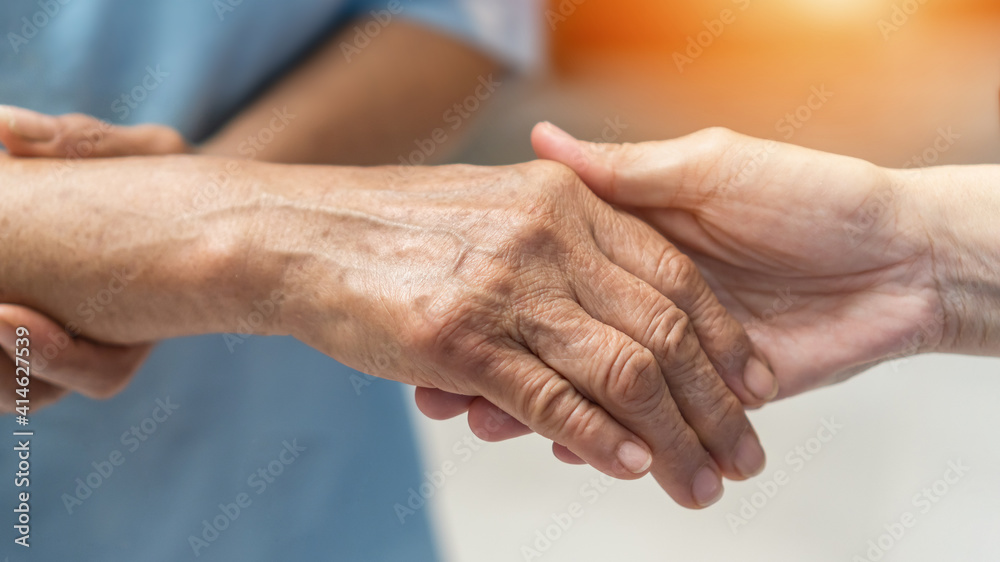 Parkinson disease patient, Alzheimer elderly senior, Arthritis person's hand in support of nursing family caregiver care for disability awareness day, National care givers month, aging society concept Parkinson disease patient, Alzheimer elderly senior, Arthritis person's hand in support of nursing family caregiver care for disability awareness day, National care givers month, aging society concept