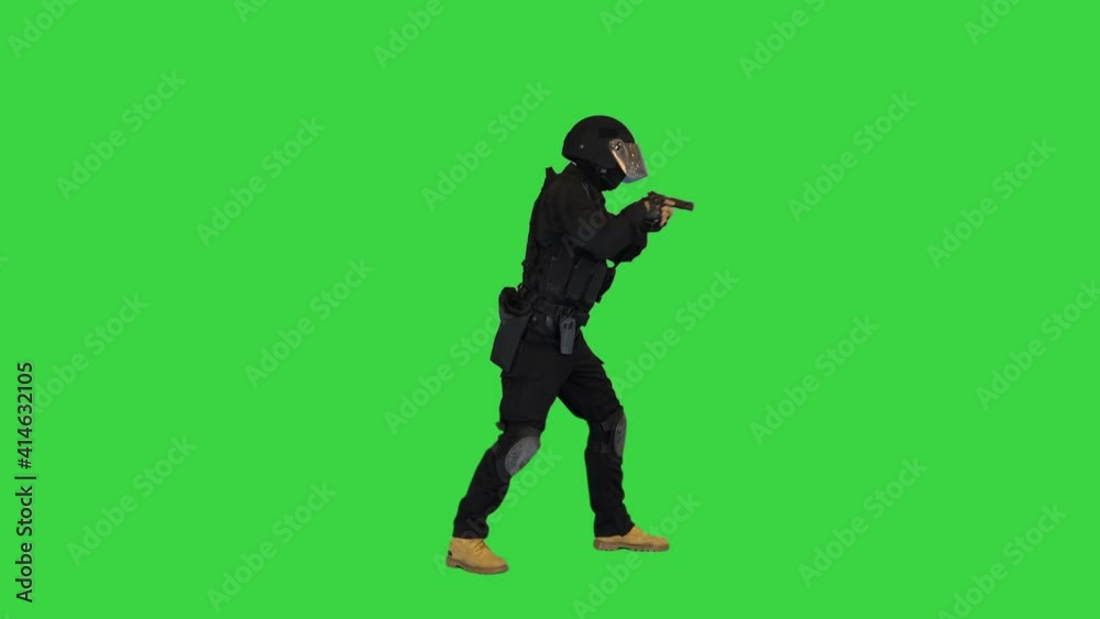 Special police unit walking in and shooting from hand gun on a Green Screen, Chroma Key. Special police unit walking in and shooting from hand gun on a Green Screen, Chroma Key.