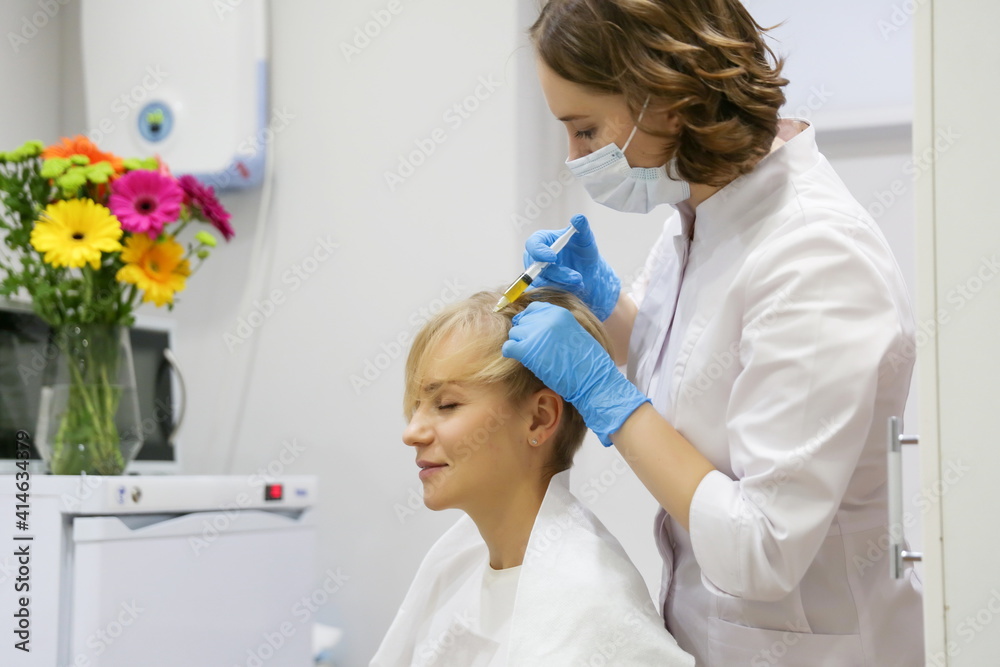 the trichologist gives injections with vitamins into the patient's head. hair care procedures in the beautician's office the trichologist gives injections with vitamins into the patient's head. hair care procedures in the beautician's office