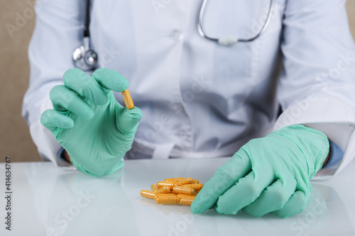 doctor's hand holds a pill close up