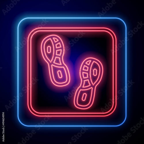 Glowing neon Human footprints shoes icon isolated on black background. Shoes sole. Vector.