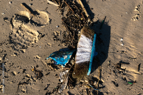 broom used on the beach washed by the waves, pollution and garbage dangerous.