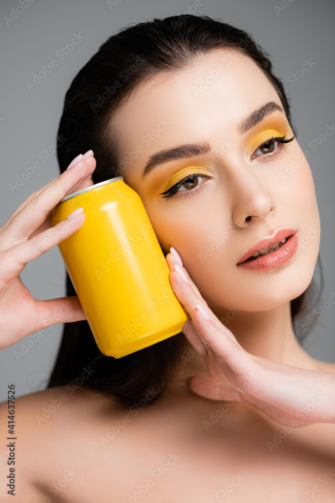 brunette woman holding yellow can with soft drink isolated on grey brunette woman holding yellow can with soft drink isolated on grey