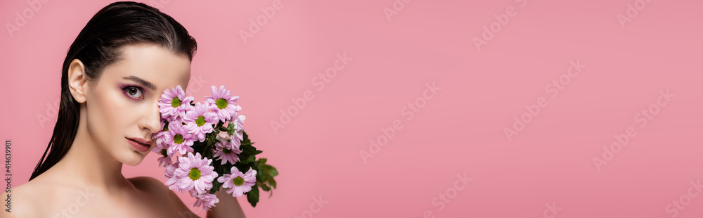 young sensual woman holding flowers isolated on pink, banner
