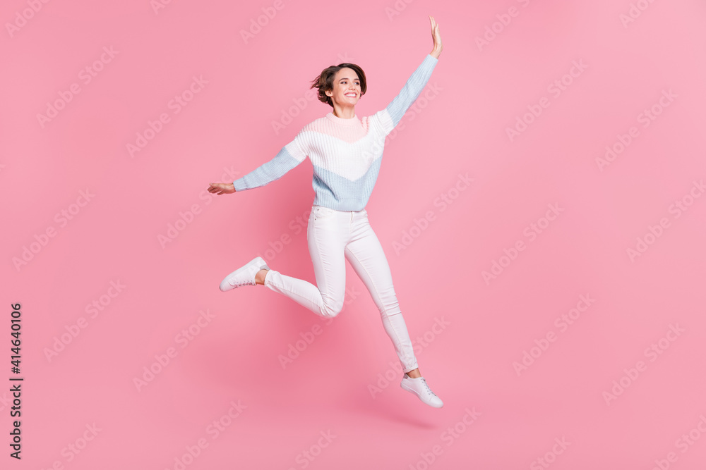 Full length photo portrait of excited girl jumping up isolated on pastel pink colored background Full length photo portrait of excited girl jumping up isolated on pastel pink colored background