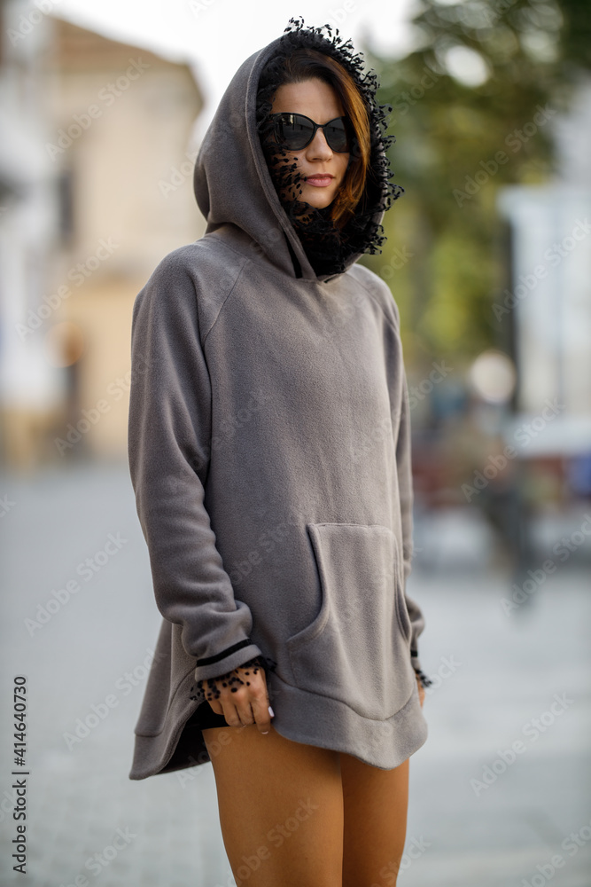 Young woman dressed in fashion hoodie posing outdoor Young woman dressed in fashion hoodie posing outdoor