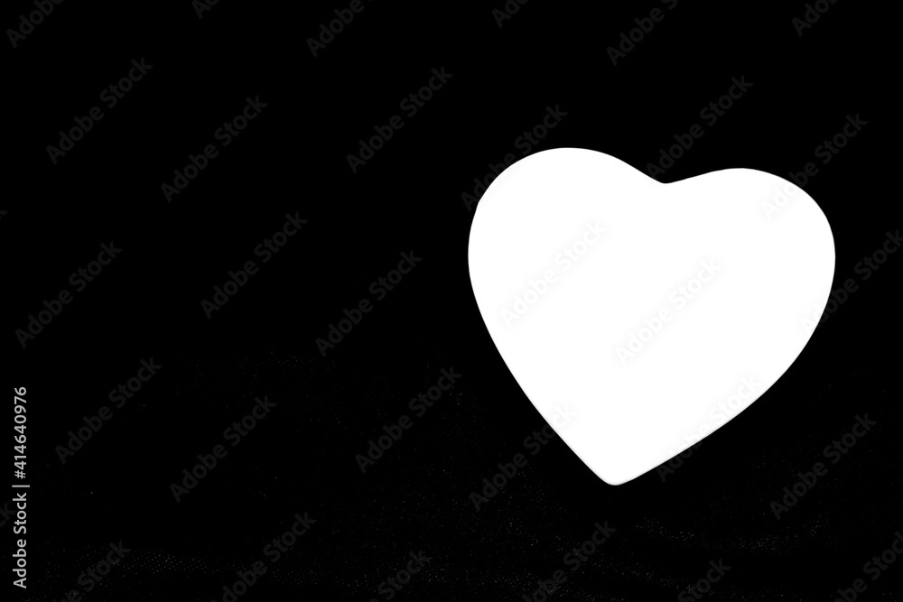 Big image of a heart shaped, white heart on a black background. Black and white picture. Light shape. Series of symbolic images. Sign of love. Love symbol. Big image of a heart shaped, white heart on a black background. Black and white picture. Light shape. Series of symbolic images. Sign of love. Love symbol.