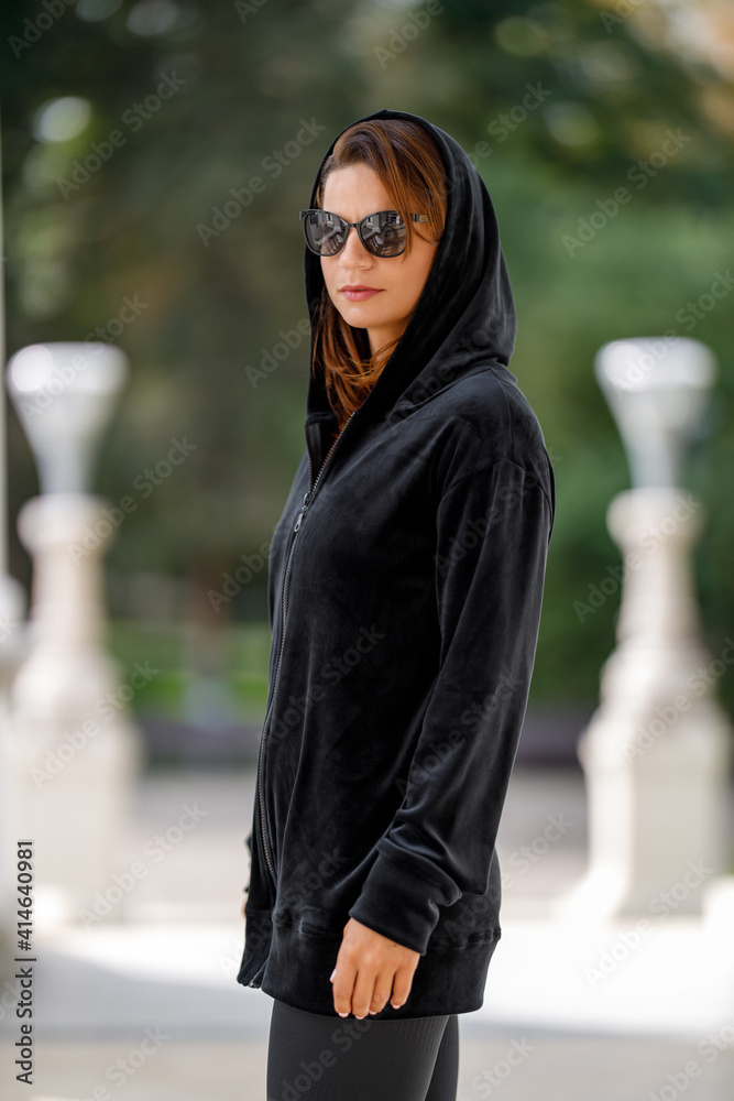 Young woman dressed in fashion hoodie posing outdoor Young woman dressed in fashion hoodie posing outdoor