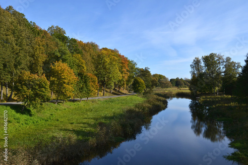 Fototapeta Naklejka Na Ścianę i Meble -  Autumn landscape beautiful colored trees over the river, glowing in sunlight. wonderful picturesque background. color in nature. gorgeous view.
