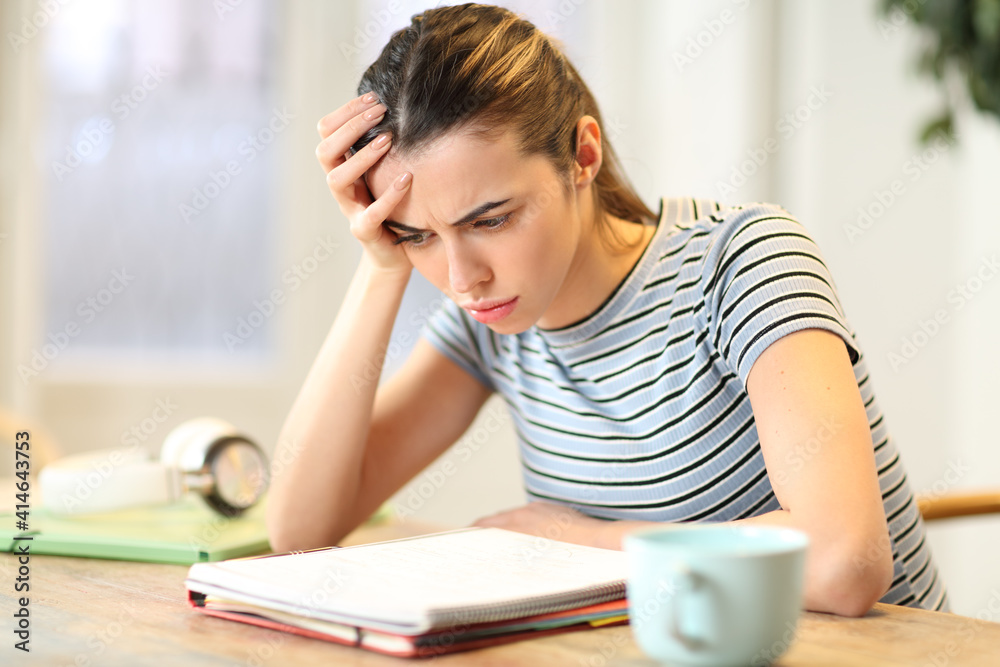 Frustrated student studying reading notes at home Frustrated student studying reading notes at home