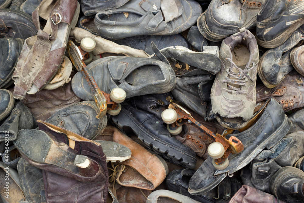 A lot of old trash shoes with pair of rusty roller skates
