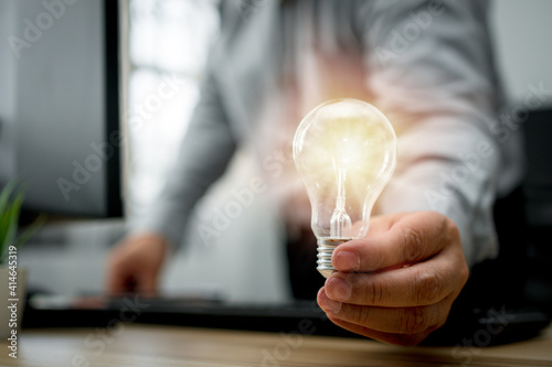 Businessman holding lightbulb and feeling happy by new innovation and ideas for success business panels. Concept of innovation creative technology ideas for Business solution