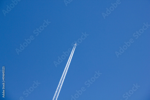 Aeroplane in a blue sky with vapour trails