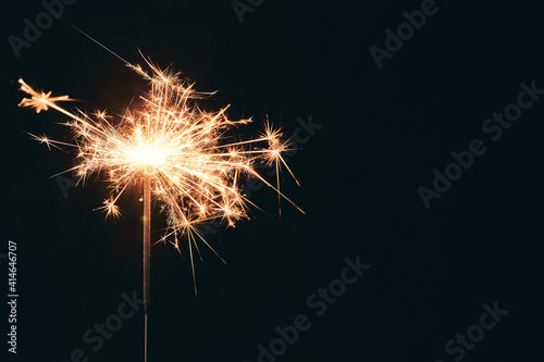 Burning party sparkler isolated on black background. Bengal