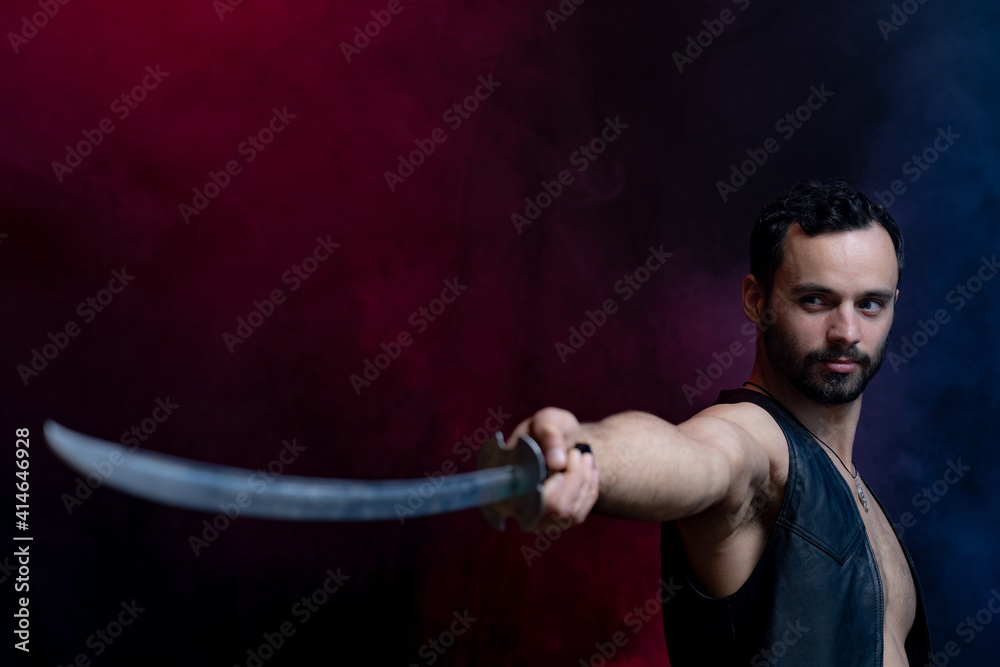 Muscular Man posing with long sword isolated on black and smoked background