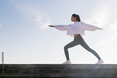 young oriental woman practicing yoga at sunrise